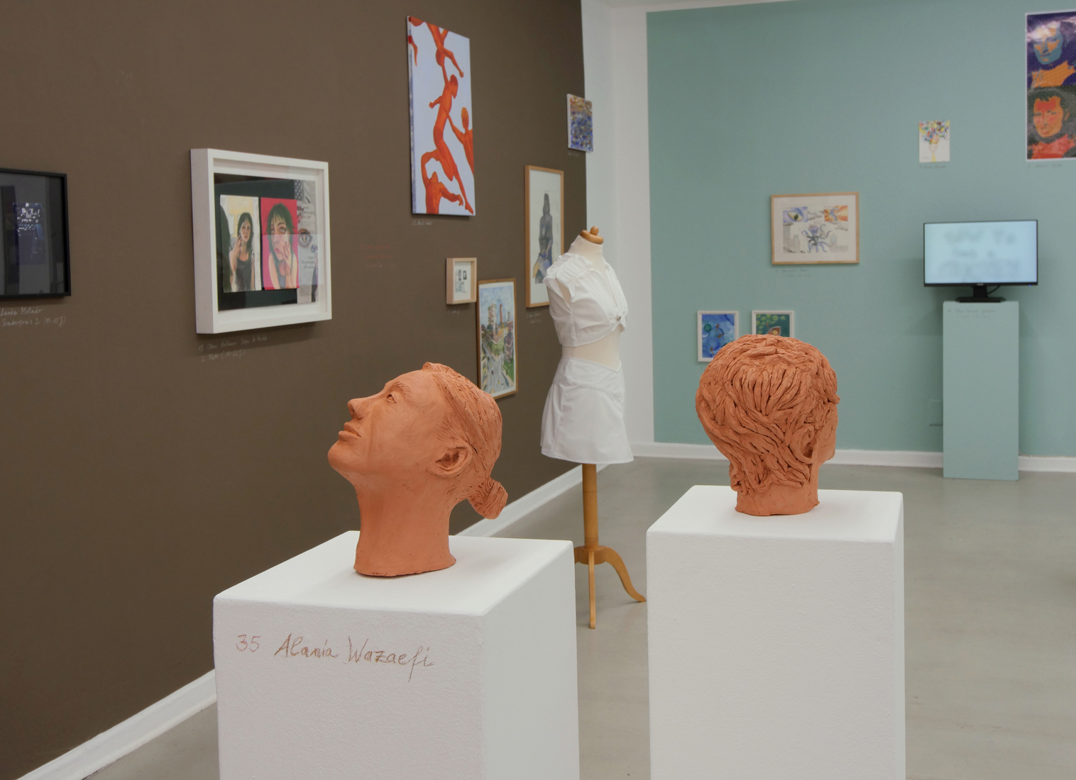 MiK Jugendkunstschule Berlin Mitte - Ein Galerieraum mit zwei Stehlen im Vordergrund auf denen zwei Tonköpfe stehen.